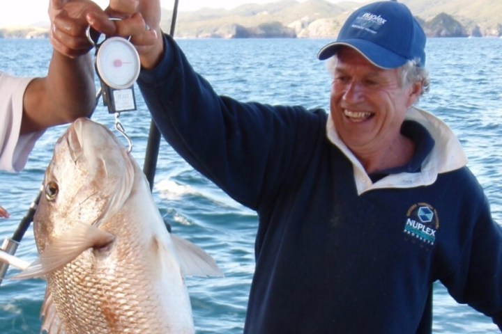 a person holding a fish on a boat in a body of water